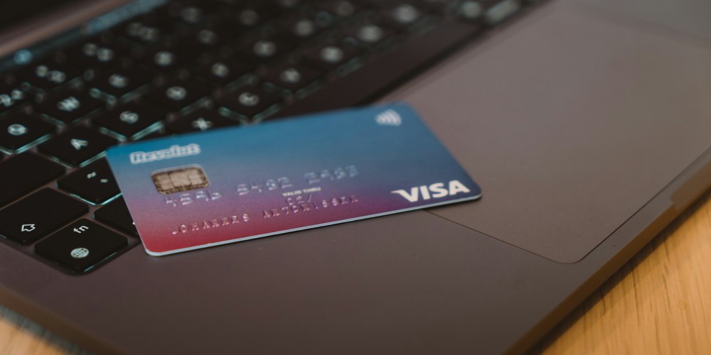 クレジットカード決済のイメージ。ノートパソコンの上に置かれたクレジットカード